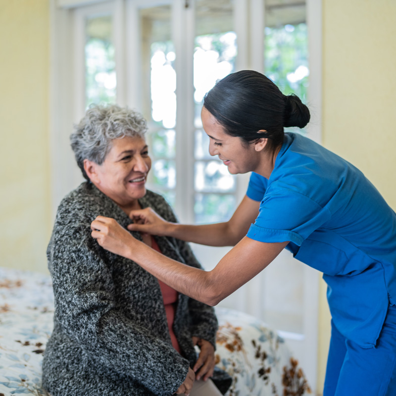 nurse helping a lady with jacket