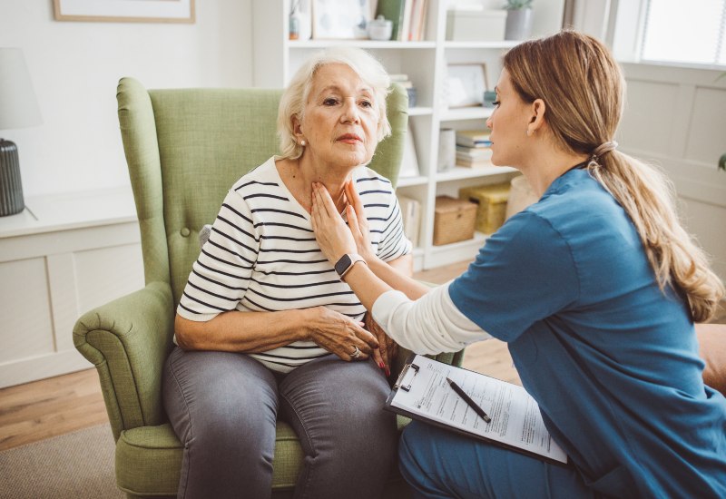 Healthcare worker checking a senior patient’s speech during a home visit in Glenview & Northbrook